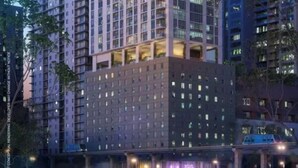Un edificio de gran altura con varios pisos, ventanas amplias y balcones.
