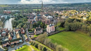 Vue aérienne d’une ville avec une église imposante, des quartiers résidentiels et une rivière.