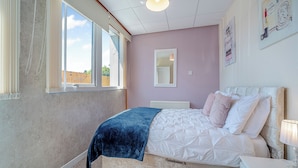 A bedroom with a bed, a bedside table, a window, and a wall-mounted mirror. - 1 Ladyknowe - UK39970 (Moffat)