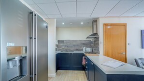 A modern kitchen with a built-in refrigerator, a microwave, and a gas stove. - 1 Ladyknowe - UK39970 (Moffat)