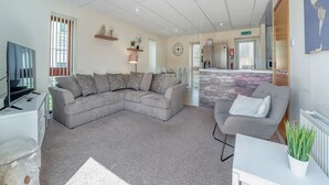 A modern living room with a sectional sofa, a flat-screen TV, and a dining area with a table and chairs. - 1 Ladyknowe - UK39970 (Moffat)