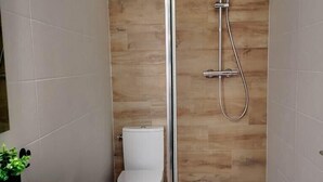 Une salle de bain moderne équipée d’une douche, de toilettes et d’un lavabo.