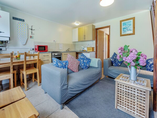A compact living space with a kitchenette, a dining area, and a seating area with two sofas.