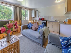 A compact living space with a sofa, dining table, and kitchenette.