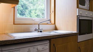 Een keuken met een inbouwvaatwasser, een magnetron en een dubbele oven.