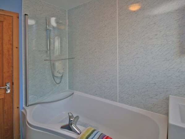 Une salle de bain équipée d’une douche, d’une baignoire et de toilettes.