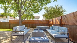 An outdoor patio area with a sofa set, a coffee table, and a patterned rug. - Hot Tub | Game Room | Sleeps 10 & Pets (Cedar Park)