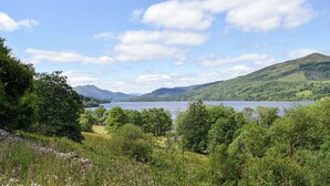 Una vista panoramica di un lago circondato da dolci colline e alberi rigogliosi.