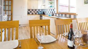 A kitchen with white cabinets, a microwave, and a window with a view.