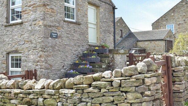 A stone building with a sign reading "Timbsie Barn".
