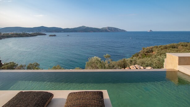 Ein Infinity-Pool mit Blick auf das Meer und ferne Berge.