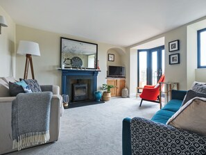 A living room with a fireplace, sofa, and television. - 3 bedroom accommodation in 11 Above Town (11 Above Town)