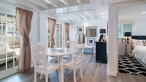 Une pièce comprenant un coin repas, un lit et un petit bureau avec une lampe.