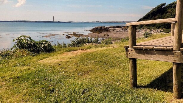 A wooden viewing platform overlooking a coastal area with a lighthouse in the distance. - 3 bedroom accommodation in Llanfwrog, near Holyhead (Llanfwrog, near Holyhead)