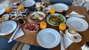 Una mesa de desayuno con platos, tazones y vasos de jugo de naranja.