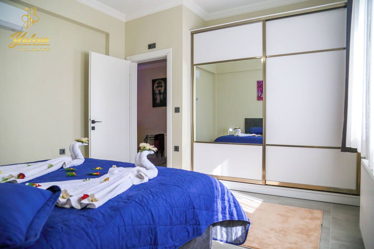 A hotel room with a bed, a wardrobe, and a mirror.