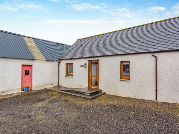 A building with a red door, a small window, and a sign reading "The Lodge".