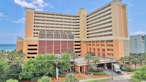 A multi-story hotel with a central atrium, parking garage, and a view of the ocean. - Beautiful Ocean Views, on 15th floor! (Myrtle Beach)