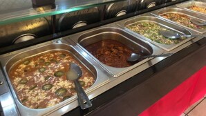 A buffet with various food options including chili, salad, and other dishes.