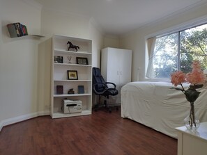 Relax in a serene bedroom with a large bed, office chair, and ample storage.
