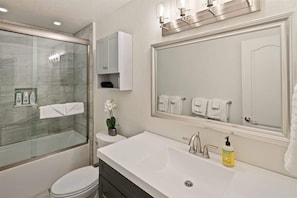 Bathtub, hair dryer, towels, shampoo