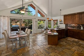 Enjoy meals in the kitchen with a central island and sink, and dine in the adjacent dining area with a view of the outdoor patio.