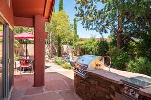 Enjoy al fresco dining on the patio surrounded by lush greenery and trees.