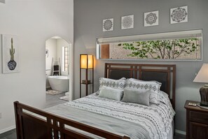 Relax in a stylish bedroom with a large bed, wooden headboard, and artwork on the walls.