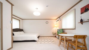 A bedroom with a bed, a desk, and a chair. - Jeju Joyhouse (Seogwipo)