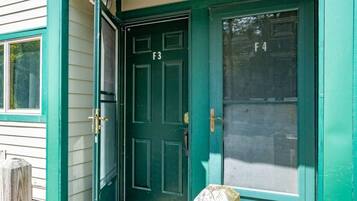 A green door with a number F3, a brass door handle, and a glass panel with the number F4.