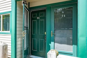 A green door with a number F3, a brass door handle, and a glass panel with the number F4.