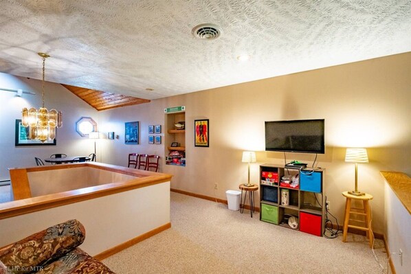 A living room with a wooden coffee table, a television, and a bookshelf.