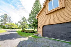 A residential building with a garage, a driveway, and a well-maintained lawn.