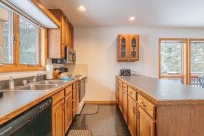 A kitchen with wooden cabinets, a microwave, a toaster, and a dishwasher. - Deerfield Village 99 (Davis)