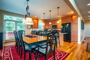 A spacious kitchen with a large island, wooden cabinets, and pendant lighting.