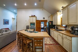 A compact kitchen with a central island, wooden chairs, and a dining table. - Family Escape w/ Hot Tub & Rec Room - Mtn Nights (Davis)