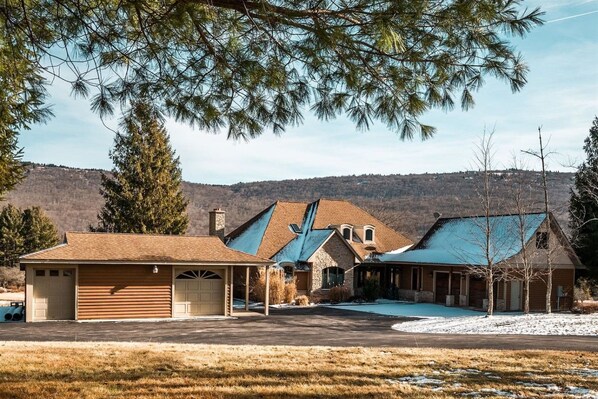 A two-story house with a garage, a covered porch, and a swimming pool.