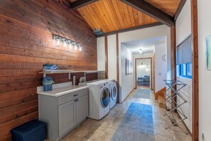 A laundry room with a washing machine, dryer, and a drying rack. - Serenity Grove - The peaceful and serene coastal cabin in the Redwoods (Fort Bragg)