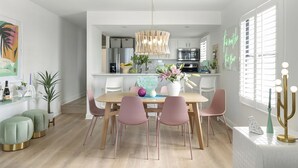Une cuisine moderne avec des meubles blancs, un îlot central et un luminaire suspendu.