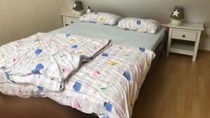 Ein Schlafzimmer mit einem Bett, zwei Nachttischen und einem Beistelltisch.