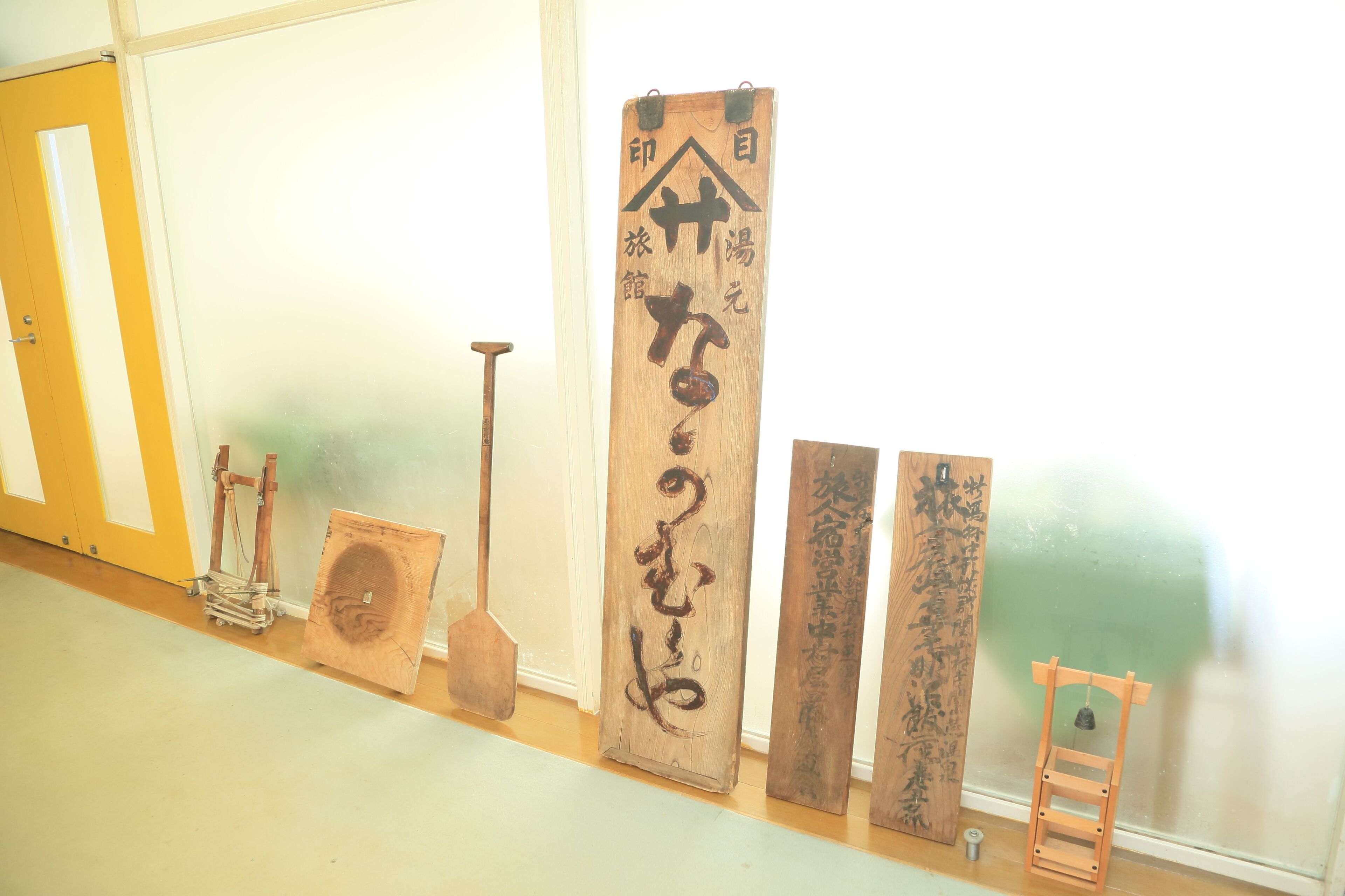 A hallway with wooden plaques and traditional Japanese tools.