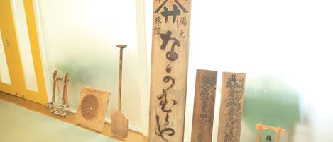 A hallway with wooden plaques and traditional Japanese tools.