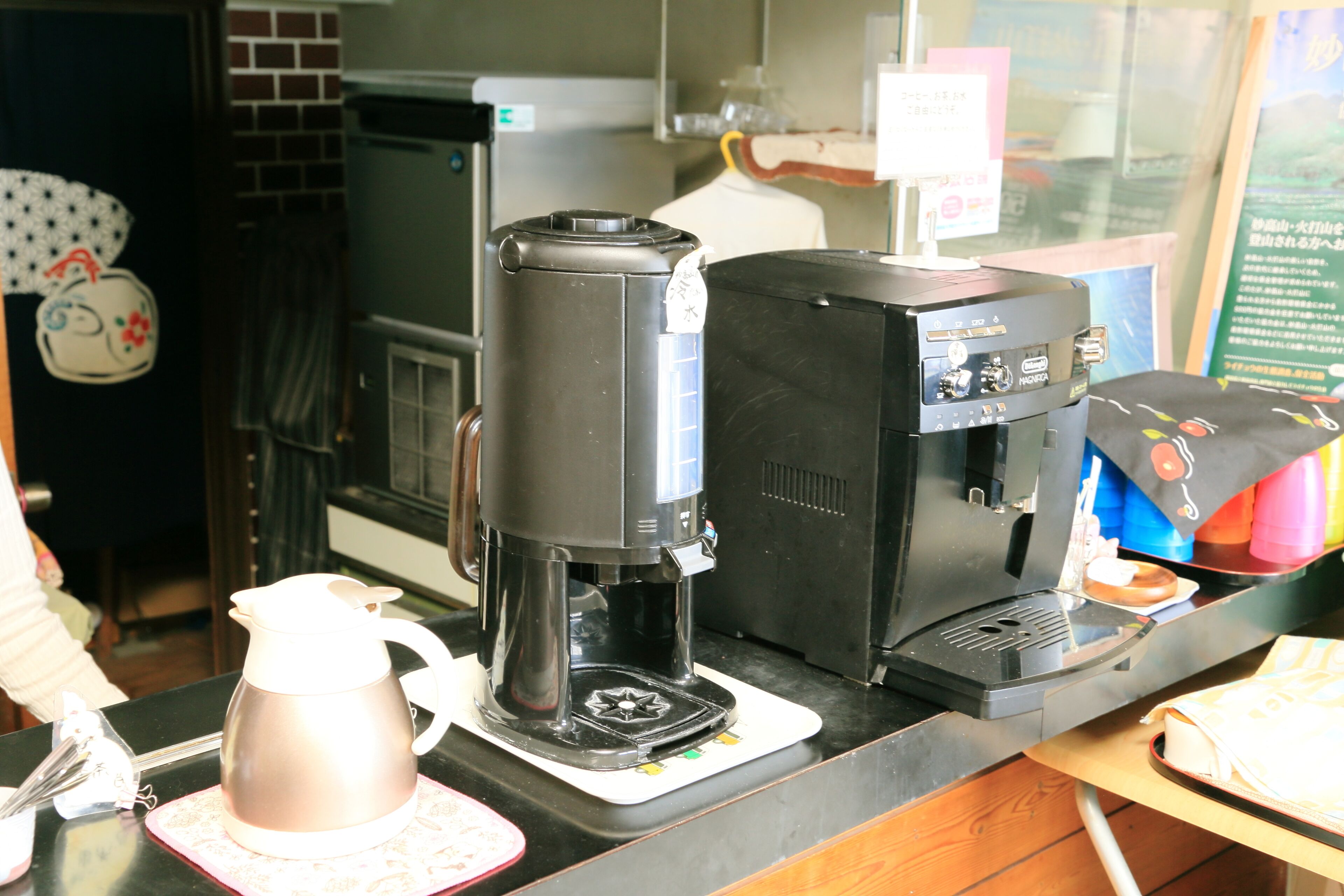 Una macchina da caffè e un boccale su un piano di lavoro.