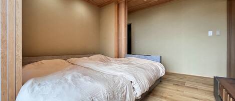 Un dormitorio con cama, techo de madera y piso de madera.