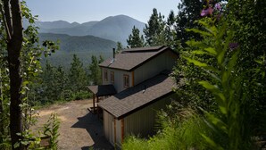 Een chalet met een tweelaags gebouw, een schoorsteen en een klein terras.