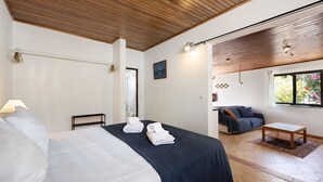 A hotel room with a bed, a desk, a chair, a window, and a view of the outdoors. - Apartment 'A Cerca - A' close to the Beach with Shared Pool & Wi-Fi (Lagos)
