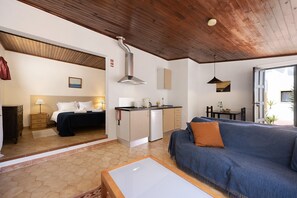 A room with a bed, a sofa, a kitchenette, and a view of the outdoors. - Apartment 'A Cerca - A' close to the Beach with Shared Pool & Wi-Fi (Lagos)