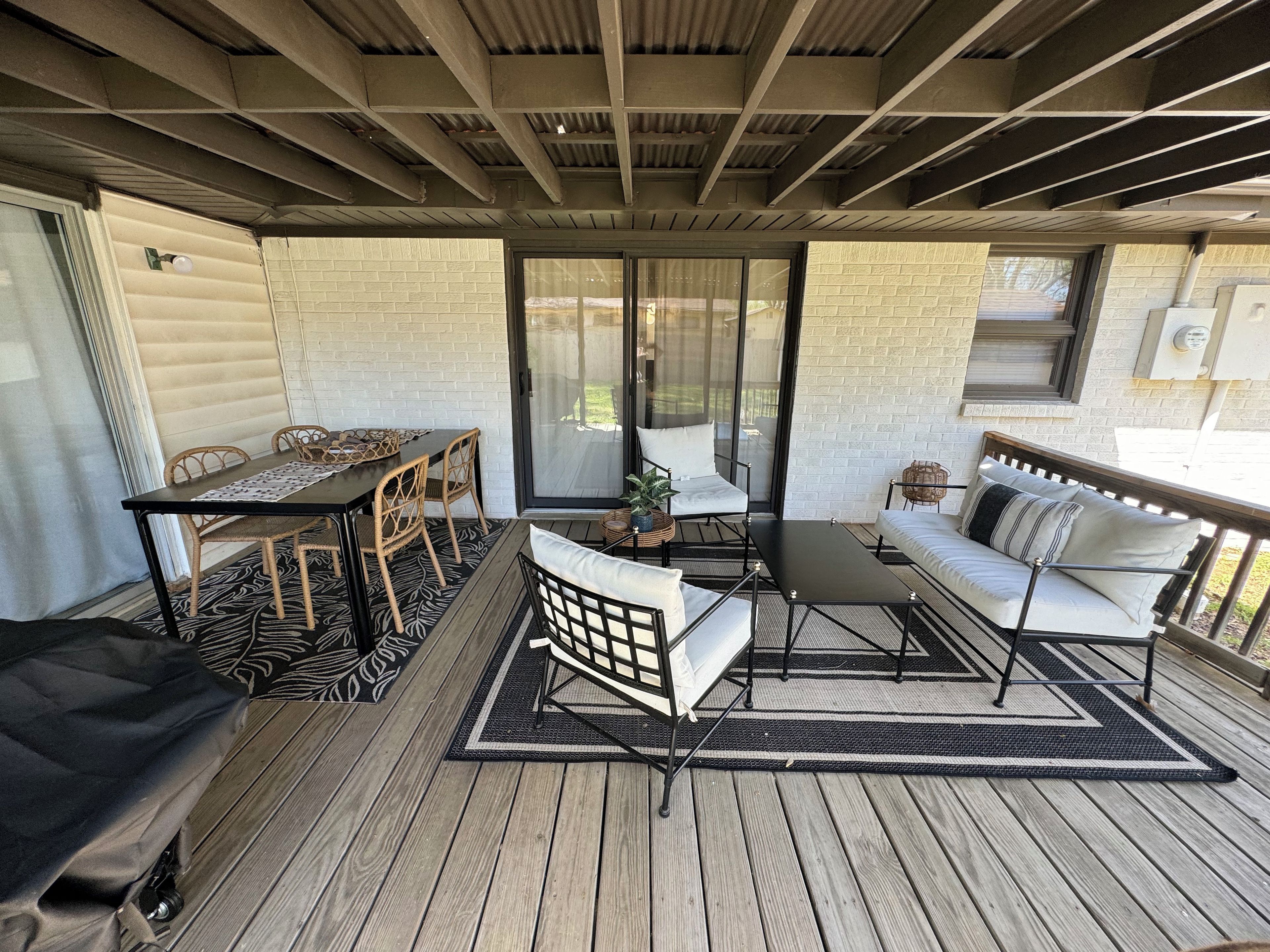 Une terrasse extérieure couverte, avec une table et des chaises, un canapé et un banc.