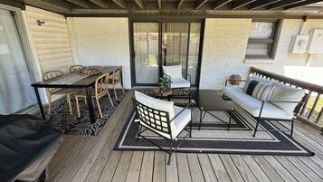Une terrasse extérieure couverte, avec une table et des chaises, un canapé et un banc.
