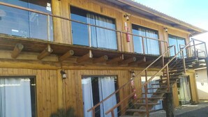 Un edificio de madera con una escalera que lleva a un balcón.